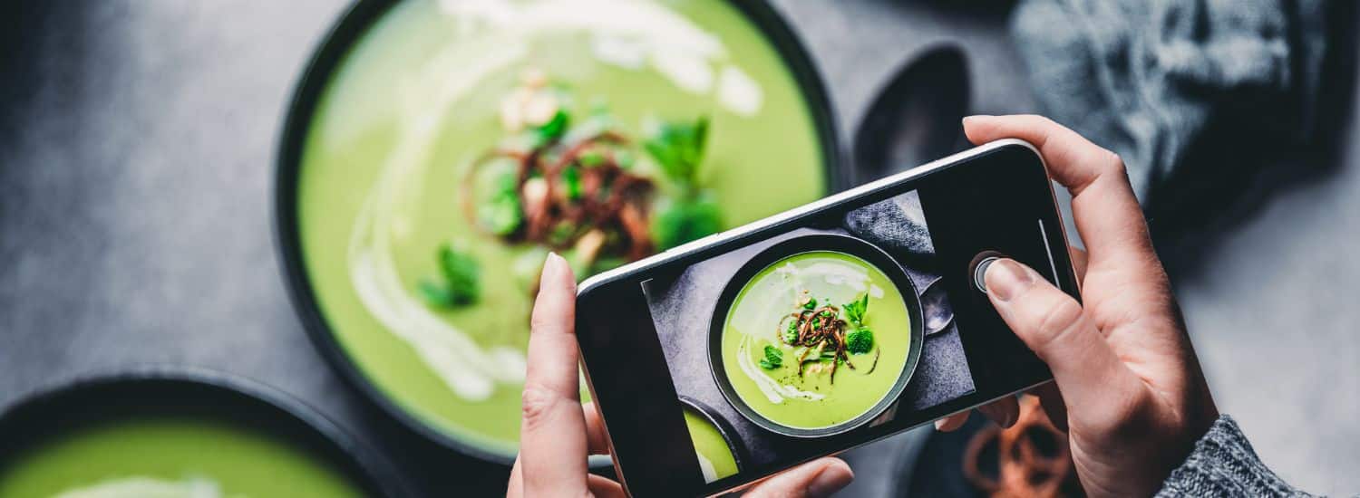 Canva: pessoa tirando foto de comida com smartphone