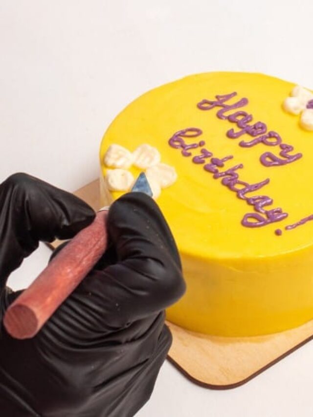 bentô cake frases: confeiteira com luvas e avental decorando pequeno bolo de aniversário