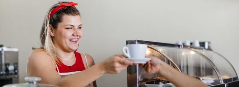 mentalidade empreendedora: pessoa em seu estabelecimento servindo café