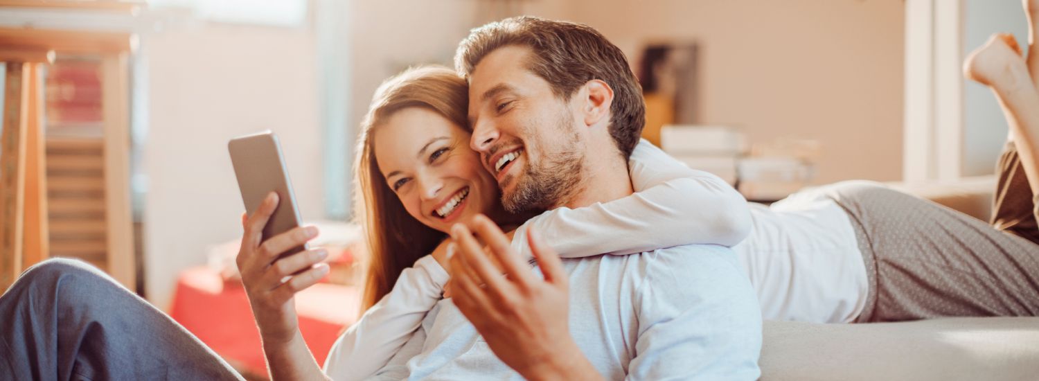 flyer de divulgação: casal se abraçando enquanto olha para celular