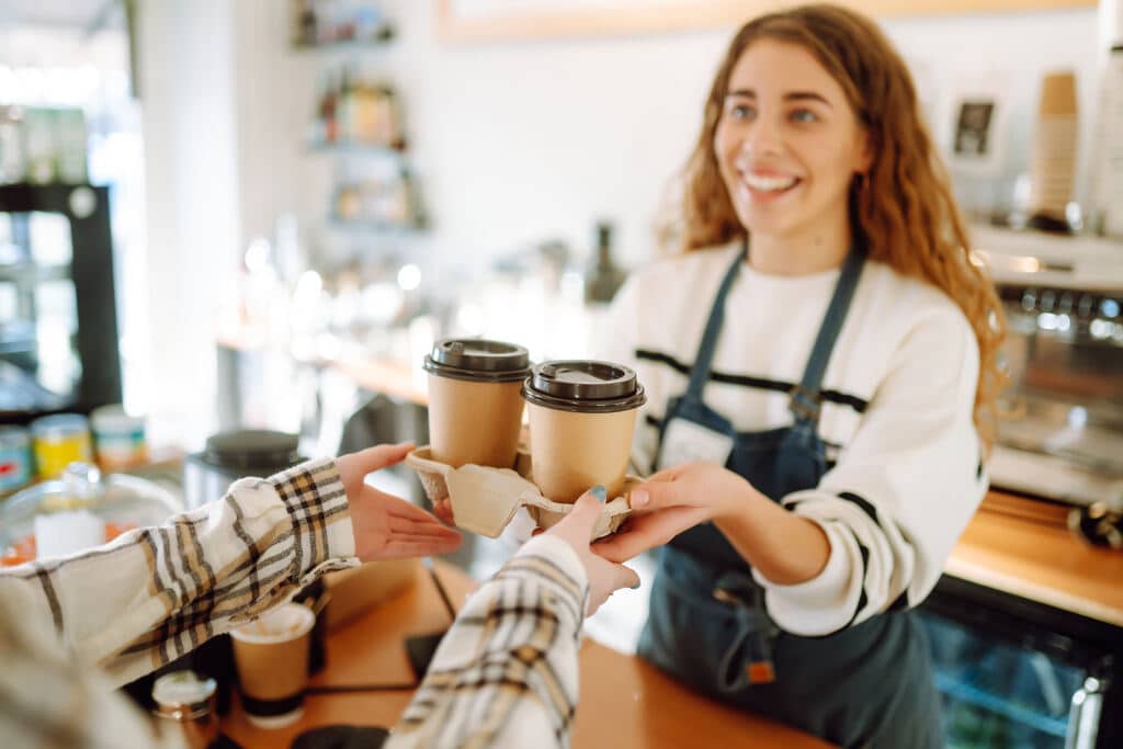 mulher sorrindo entregando café