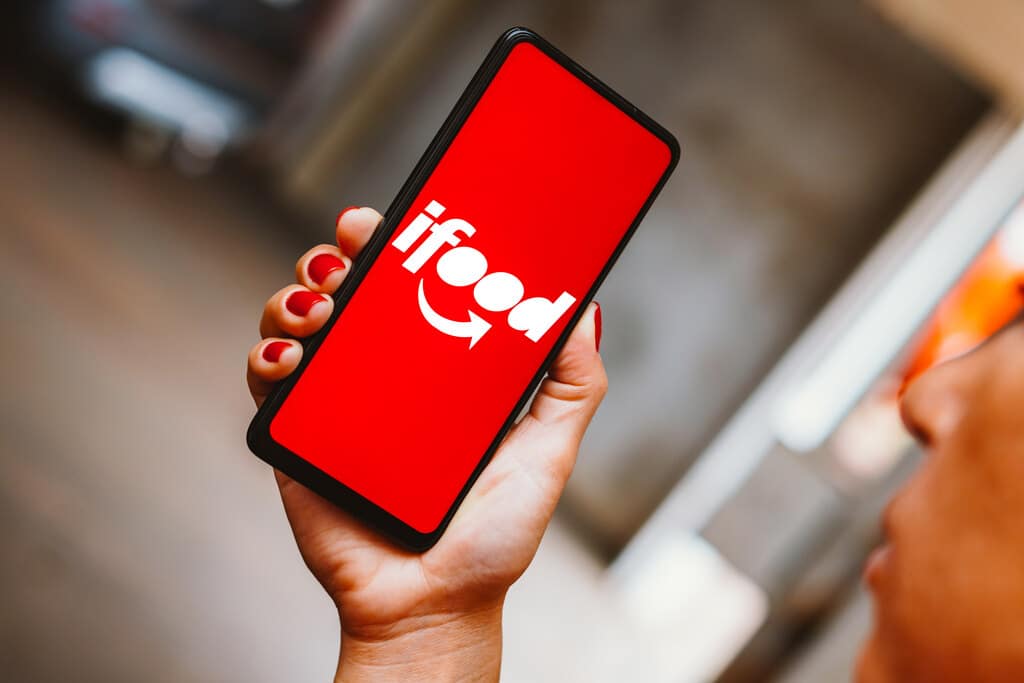 mao segurando um celular com ifood