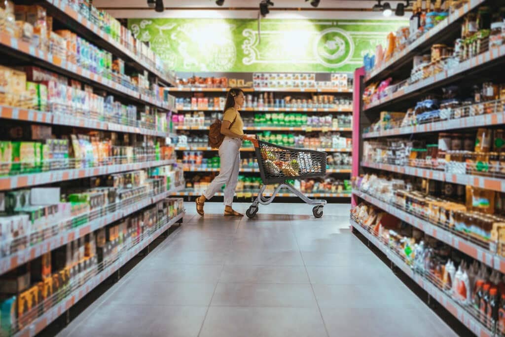 mulher andando com carrinho no supermercado