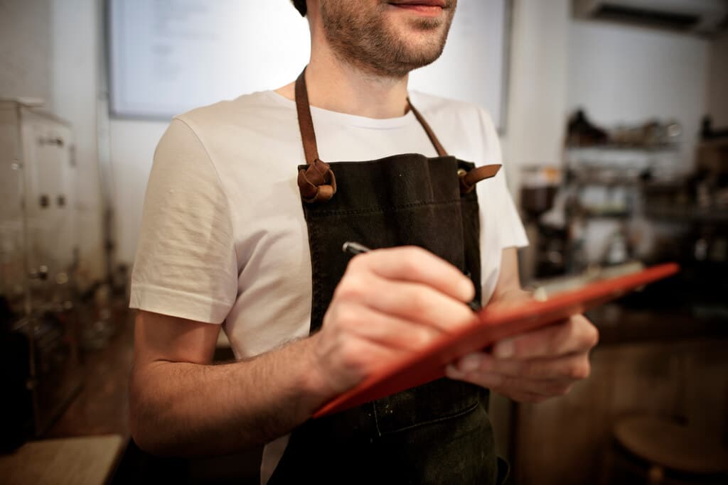 homem anotando pedido de cliente