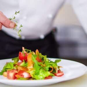 alimentação e nutrição: chef terminando de preparar um prato de salada