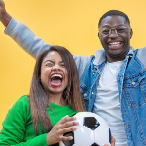 Brazilian fans couple happy celebrating football or soccer game on yellow and green background