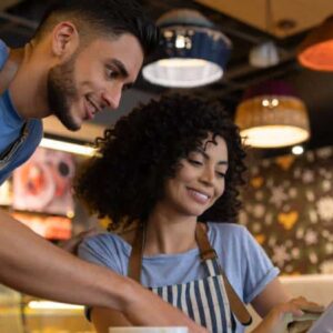 calendário 2023: homem e mulher empreendedores olhando para tablet em seu estabelecimento.