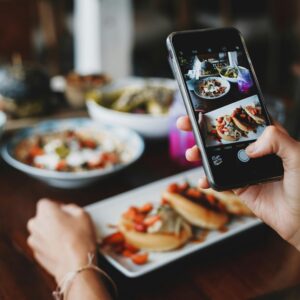 foto de uma pessoa com o celular, mostrando como tirar fotos de comida no ifood