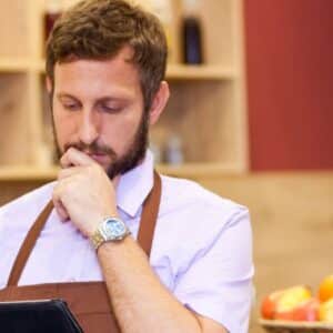 código cest: pessoa olhando pensativa para tablet em seu estabelecimento