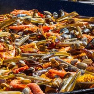 Homem cozinha paella, prato típico da culinária espanhola