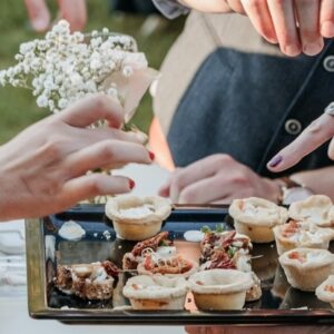 finger food: pessoas pegando comidinhas em bandeja durante festa