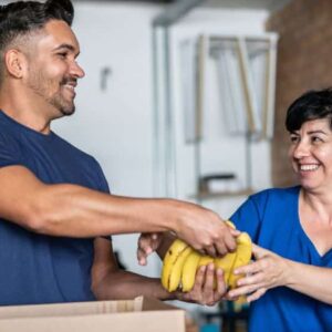 fome: pessoas participando de ação voluntária entregando fruta