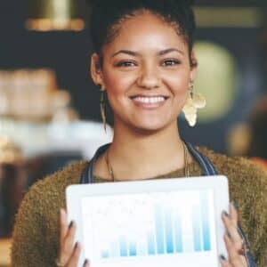 gestão escalável: empreendedora negra segurando tablet com relatório em gráficos.