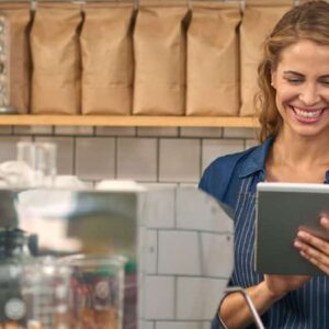 índice de lucratividade: gestora de negócio sorrindo vendo tablet