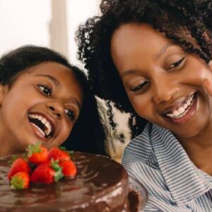 mães empreendedoras: mãe e filha se gravando com celular e mostrando bolo