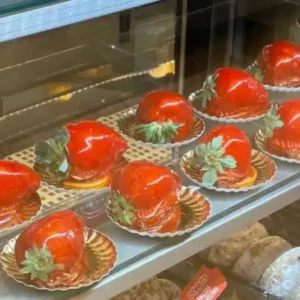 Vitrine de confeitaria com vários morangos do amor para vender