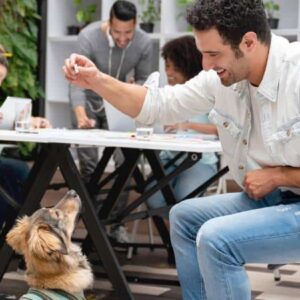 restaurantes pet friendly: homem sentado junto com outras pessoas à mesa, dando petisco ao cachorro