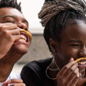 snacking: duas pessoas usando batata frita como bigode e sorrindo