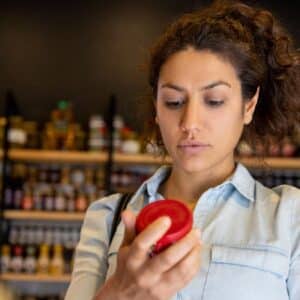 tabela nutricional: pessoa lendo com atenção informações impressas em embalagem de produto